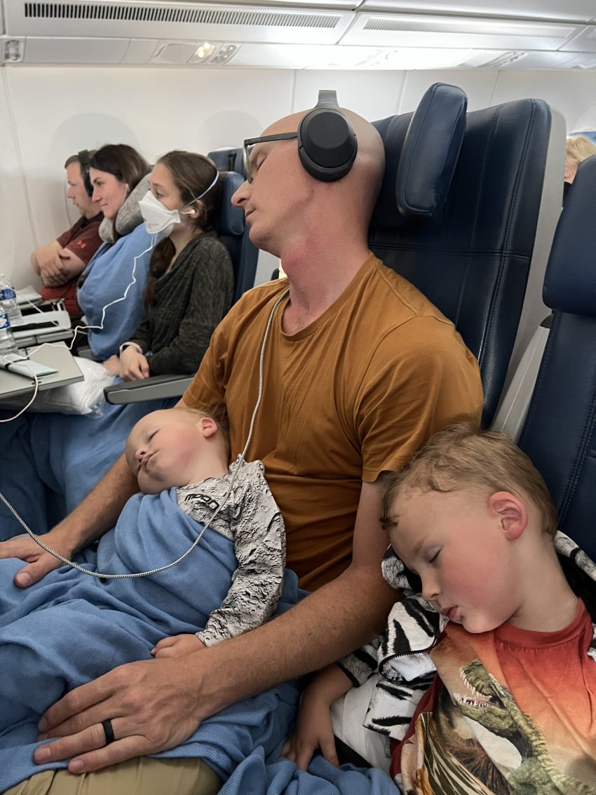 Lap baby sleeping on a parent on the airplane