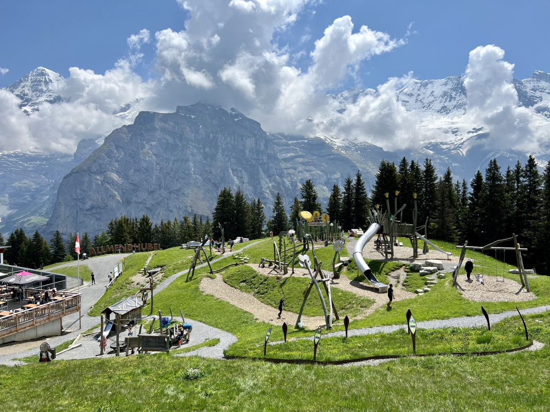 A vibrant playground set against the majestic Swiss Alps, where kids can play in the heart of nature.